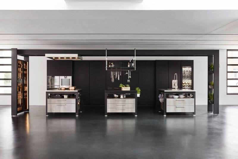 Cuisine haut de gamme noire avec îlots inox sur mesure. Design épuré, espaces ouverts et rangements professionnels pour un aménagement d’exception.