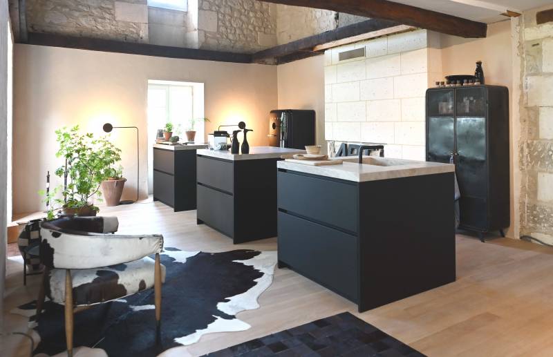 Cuisine moderne avec îlots en quartzite et meubles noirs, mêlant design contemporain, matériaux nobles et ambiance raffinée pour un intérieur premium.